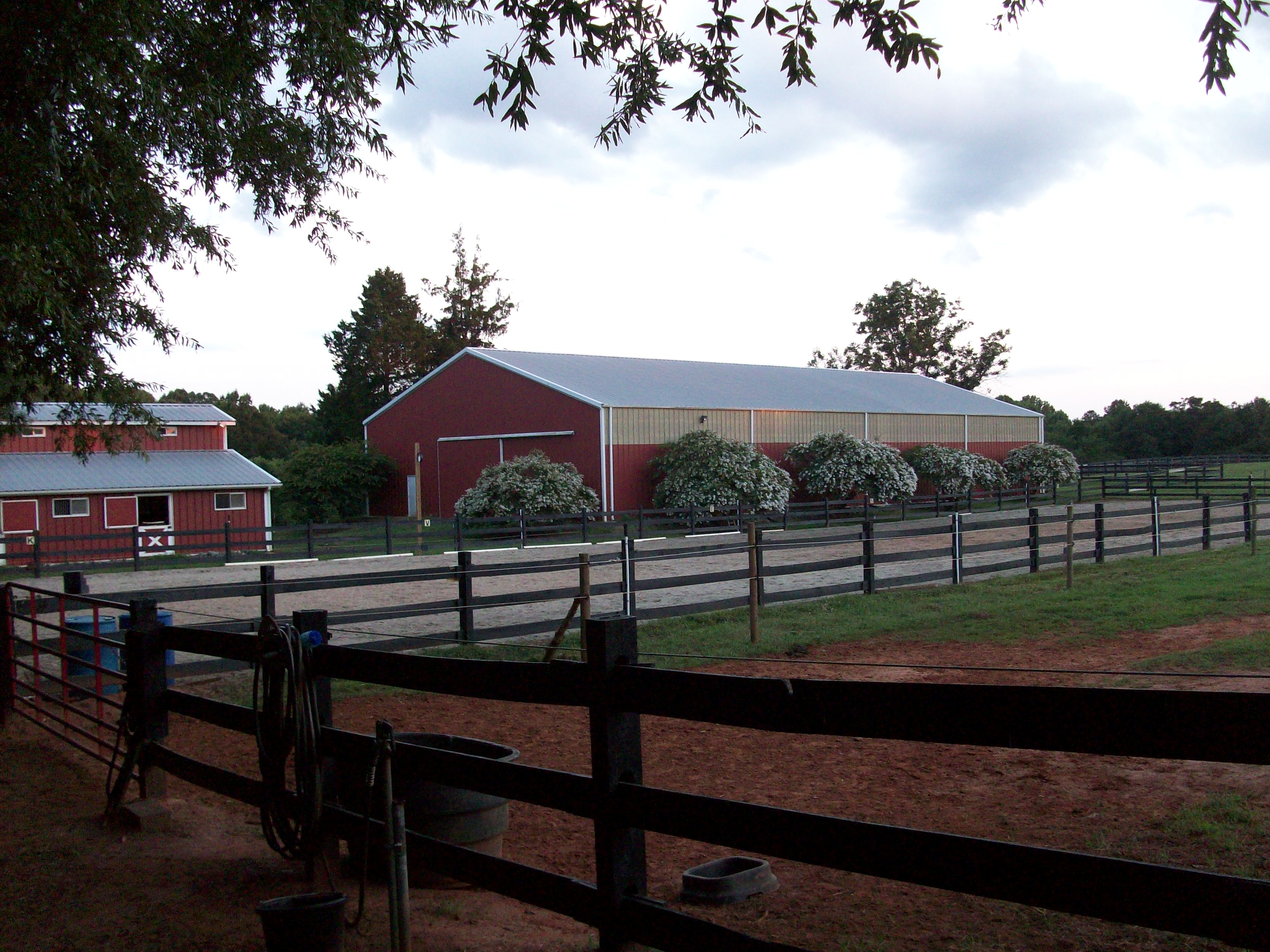 View of barn and indoor/outdoor riding arenas
